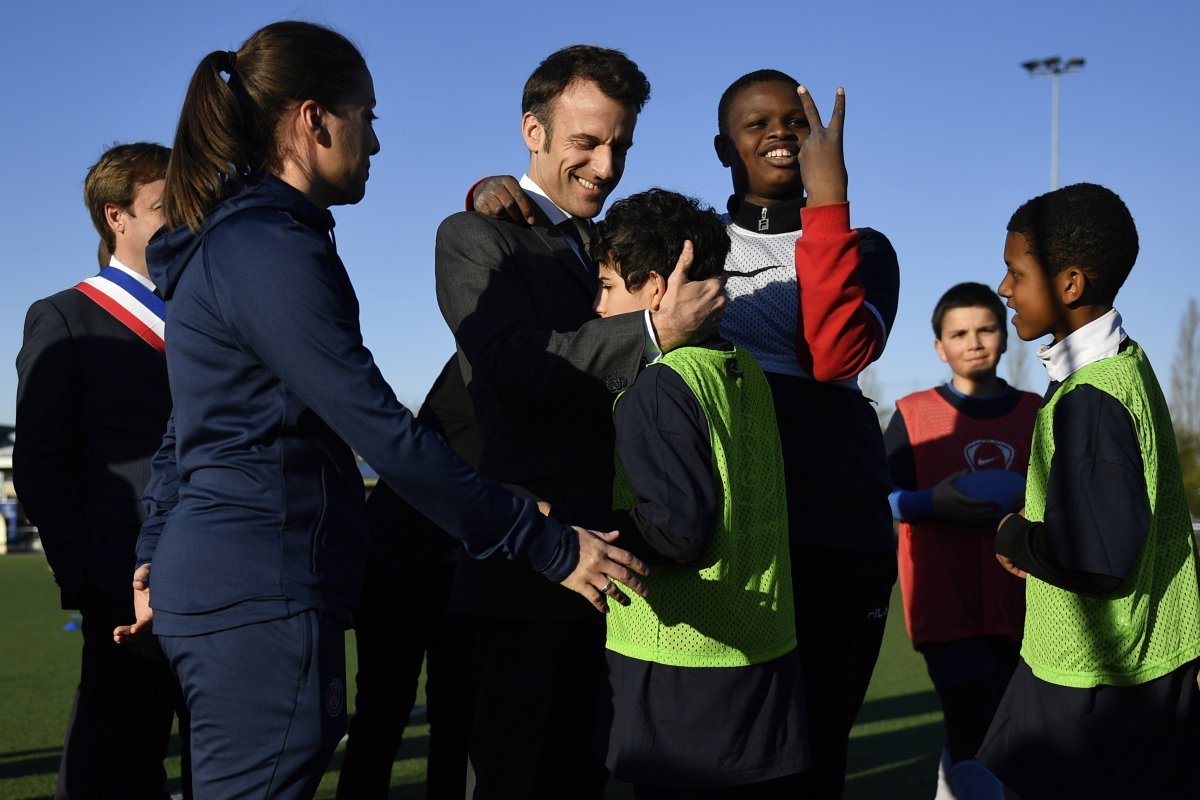 에마뉘엘 마크롱 프랑스 대통령(가운데)이 지난해 4월 프랑스 파리 인근 클라마르에 있는 한 경기장에서 아이들을 포옹하고 있다. 마크롱 대통령은 올해 출산휴가를 확대하고 난임 퇴치 대책을 내놓기로 했다. 클라마르=AP 뉴시스