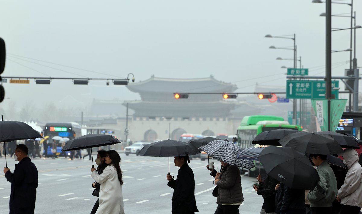 서울 종로구 종로구 광화문 네거리에서 우산을 쓴 시민들이 발걸음을 옮기고 있다.  2024.3.29.뉴스1