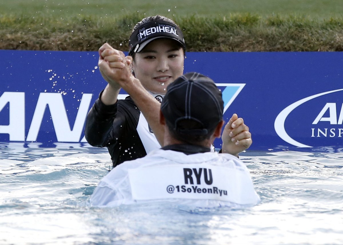 So-yeon Yoo (back), following the tournament tradition, jumped into the pond next to the 18th hole green with her caddy after winning the tournament in 2017. AP Newsis