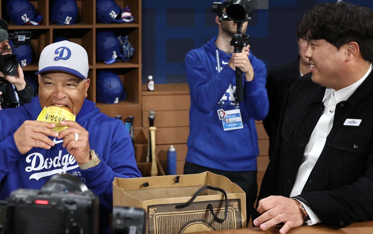 지난달 20일 서울 고척스카이돔에서 열린 미국프로야구(MLB) 공식 개막전에서 데이브 로버츠 LA 다저스 감독이 류현진 한화 이글스 선수와 만나 성심당의 대표 제품 ‘튀김소보로’를 먹으며 대화하고 있다. 뉴시스