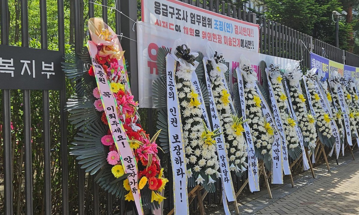 22일 복지부 청사 앞에 의대 증원을 지지하는 환자·보호자와 반대하는 의사들이 보낸 화환이 줄지어 놓여 있다. 뉴스1