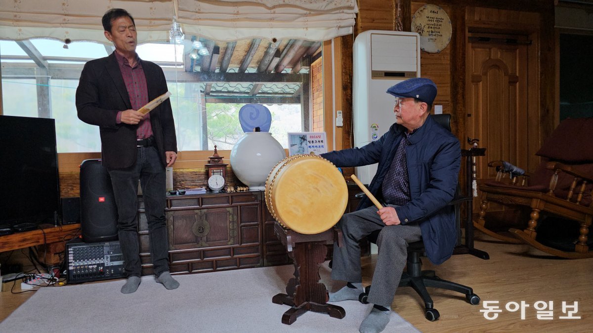 Practicing pansori to the beat of master Kim Cheong-man (right).