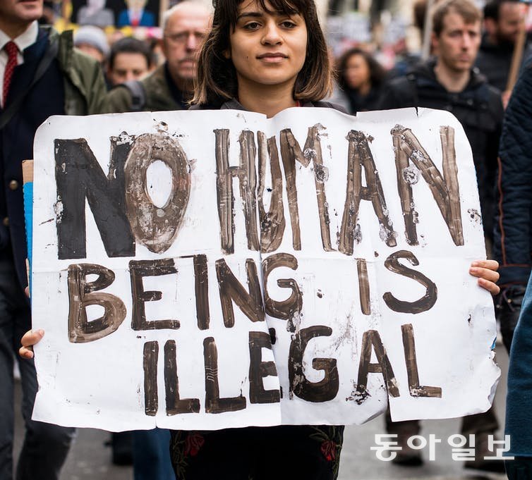 ‘어떤 인간도 불법적이지 않다’라는 플래카드를 든 시위자. 조 바이든 대통령은 중남미 이민자에게 ‘불법’(illegal)이라는 단어를 썼다가 사과했다. 오픈유니버시티 홈페이지