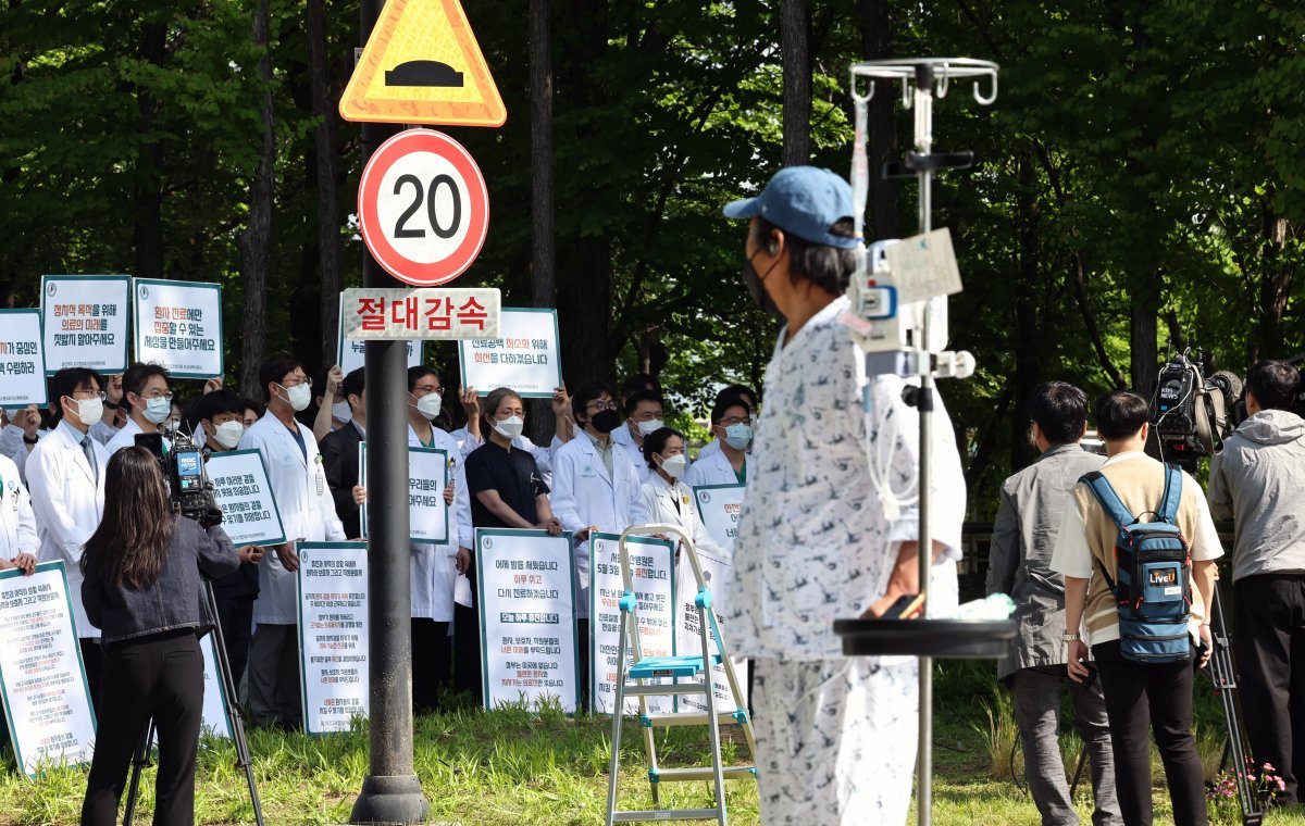 이달 3일 서울 송파구 서울아산병원에서 의사들이 피켓시위를 하는 모습을 지켜보는 환자. 뉴시스