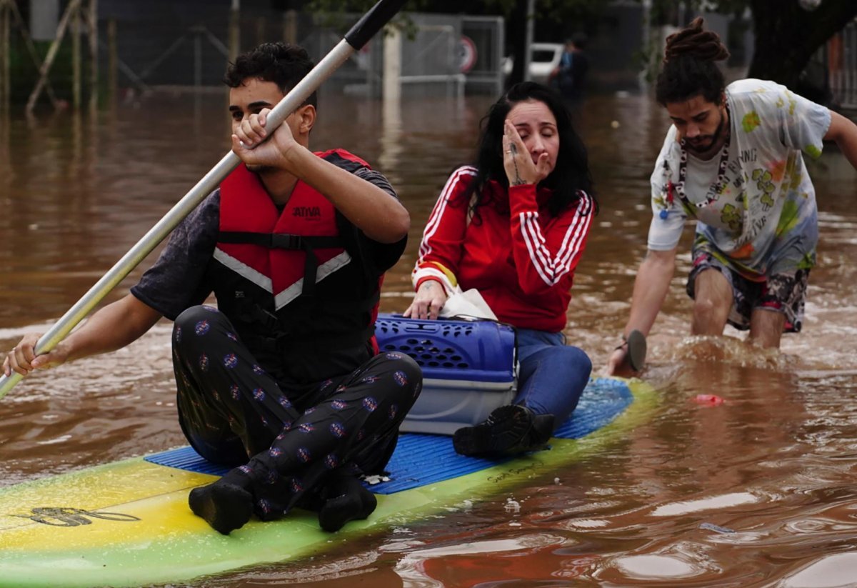 서핑보드 타고 탈출 4일 브라질 히우그란지두술주 카노아스에서 주민들이 서핑보드에 올라타 폭우로 물에 잠긴 도시를 빠져나오고 있다. 이곳에서는 폭우로 80년 만에 역대급 홍수가 발생해 최소 78명이 숨지고 105명이 실종됐다. 카노아스=AP 뉴시스