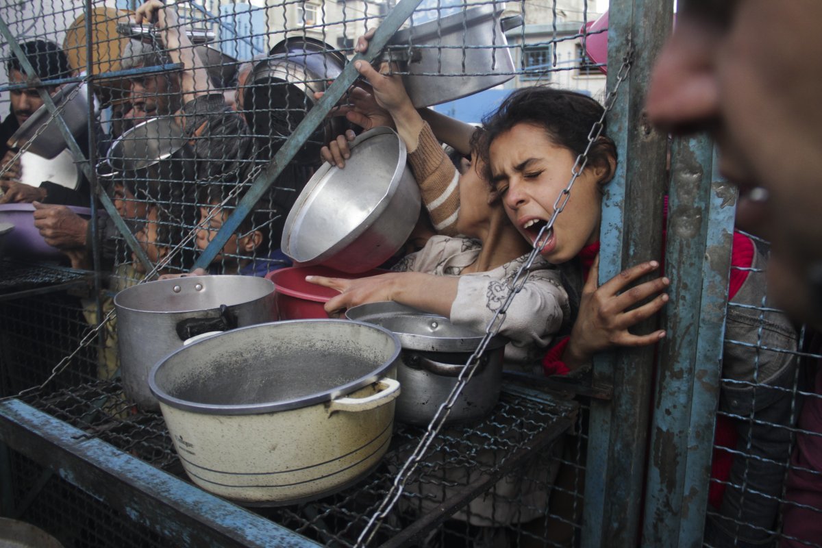 올해 3월 가자지구의 난민 캠프에서 팔레스타인 사람들이 음식을 배급받기 위해 경쟁하고 있다. AP=뉴시스