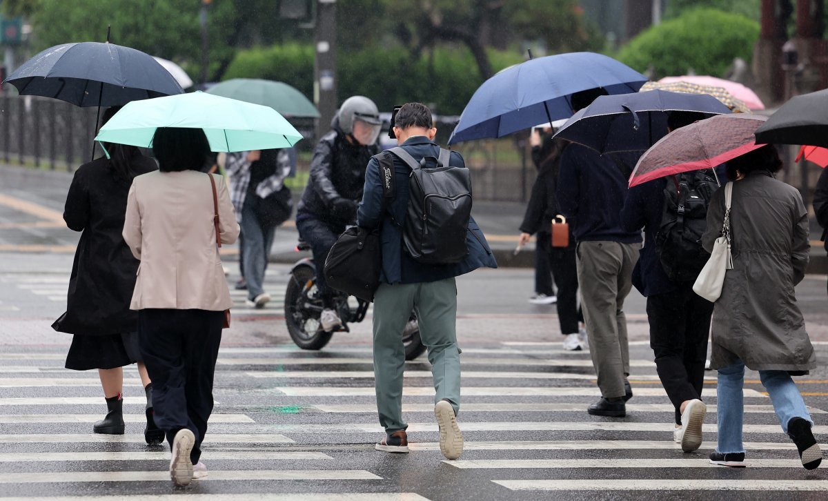 전국 대부분 지역에 비가 예보된 7일 오전 서울 종로구 세종대로사거리에서 우산을 쓴 시민들이 발걸음을 옮기고 있다. 2024.5.7/뉴스1