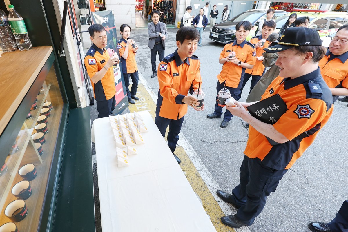 박건기 소방위가 8일 오전 서울 동작소방서에서 고3 딸 지안 양이 어버이 날을 맞아 보낸 커피차를 선물 받고 동료들에게 커피와 샌드위치를 나눠주고 있다. 2024.5.8/뉴스1