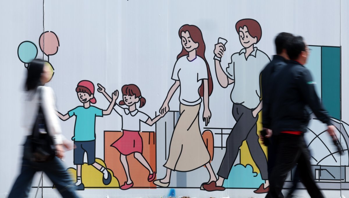 지난 2월 출생아 수가 지난해 같은 달보다 3.3% 줄어들며 처음으로 1만 명대로 내려앉은 가운데 24일 오후 서울 도심의 공사장 가림막에 그려진 행복한 가족 그림 앞으로 시민이 지나고 있다. 2024.4.24 뉴스1