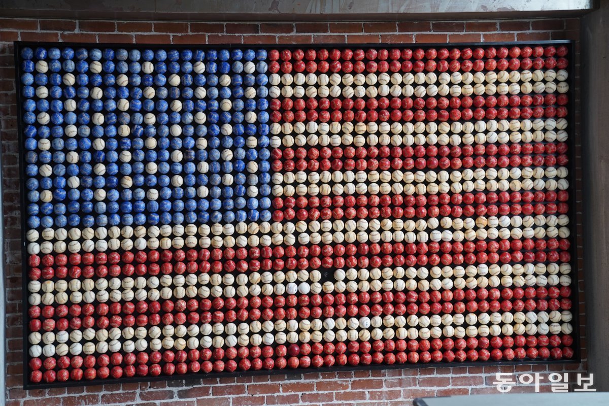 An American flag decorated with balls used in past All-Star games is displayed on a wall inside the Western Metal Building.