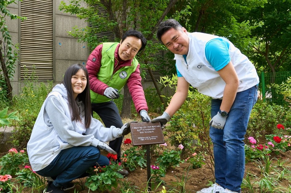 BAT로스만스 송영재 사장(오른쪽)과 (사)자연보호연맹 서울시협의회 이영도 회장(가운데)이 꽃BAT 화단에 팻말을 설치하고 있다. BAT로스만스 제공