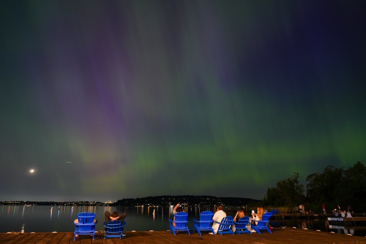 미국 워싱턴 주 렌튼에서 사람들이 워싱턴 호수 위로 빛나는 오로라를 관람하고 있다. AP 뉴시스