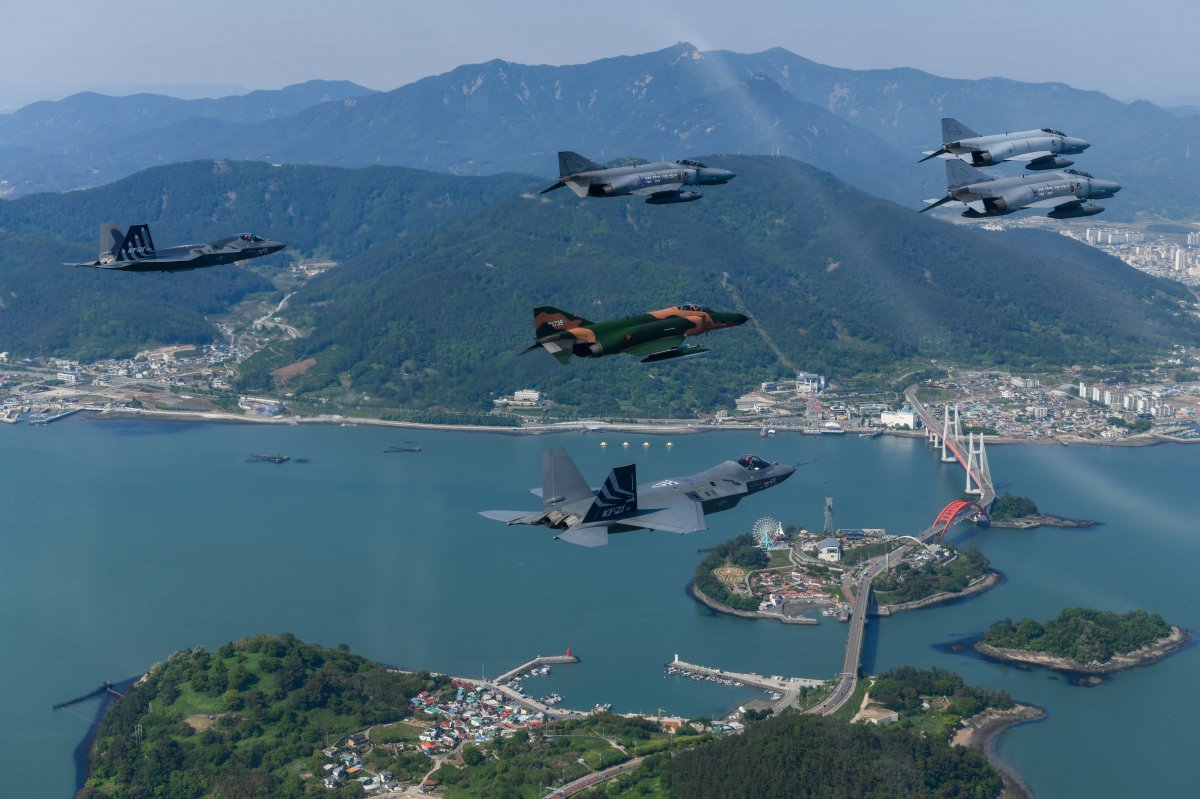 9일 팬텀 전투기 F-4E 4대로 구성된 ‘필승편대’가 고별 국토 순례 비행을 하며 경남 사천 삼천포대교 상공을 지나고 있는 
가운데 한국형 초음속 전투기 KF-21 시제기 2대(아래, 뒤)가 합류해 함께 비행하고 있다. 공군 제공