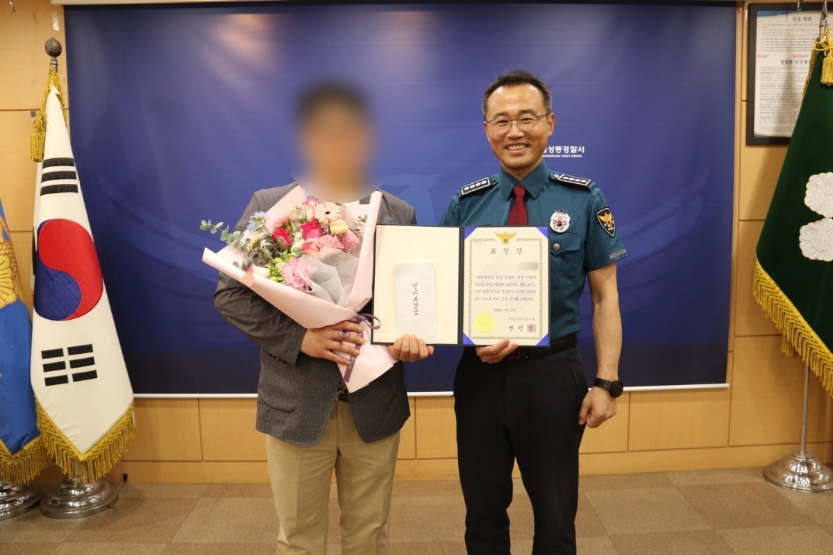 경찰이 전화금융사기(보이스피싱)범 검거에 기여한 60대 남성 A 씨에게 경찰서장 명의의 표창을 수여하고 신고 보상금을 전달하고 있다. 성동경찰서 제공
