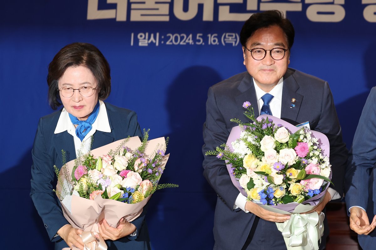 더불어민주당 국회의장 후보로 당선된 우원식 의원과 추미애 후보가 16일 서울 여의도 국회 의원회관에서 열린 제22대 국회 전반기 국회의장단 후보 선출을 위한 더불어민주당 당선자총회에서 꽃다발을 들고 인사하고 있다. 2024.5.16/뉴스1