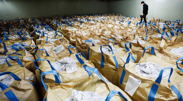 An official is checking rice being stored after purchase at a rice processing plant in Yongin, Gyeonggi Province. [뉴스1]