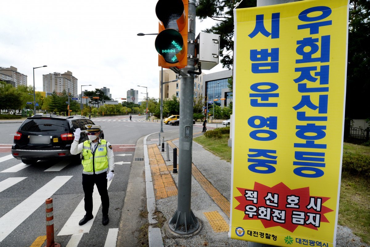 유성경찰서 교통안전계 소속 경찰관들이 22일 대전 유성구 원신흥네거리에서 ‘우회전 신호등’ 시범운영 계도 및 지도를 하고 있다.  2022.9.22/뉴스1 ⓒ News1 김기태 기자