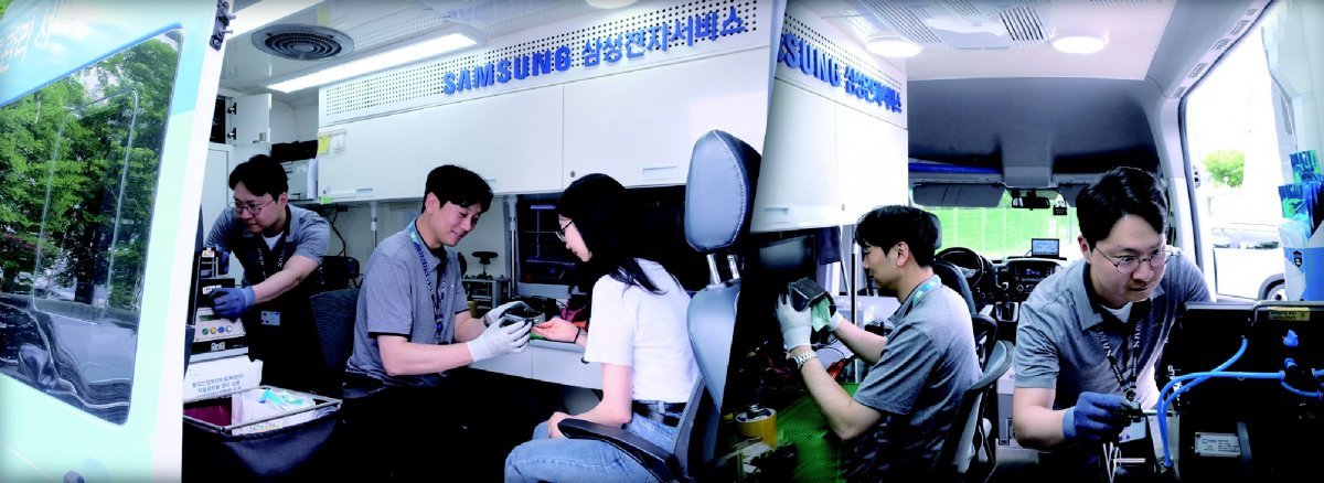 An engineer is responding to customers and checking mobile phones in a service vehicle.