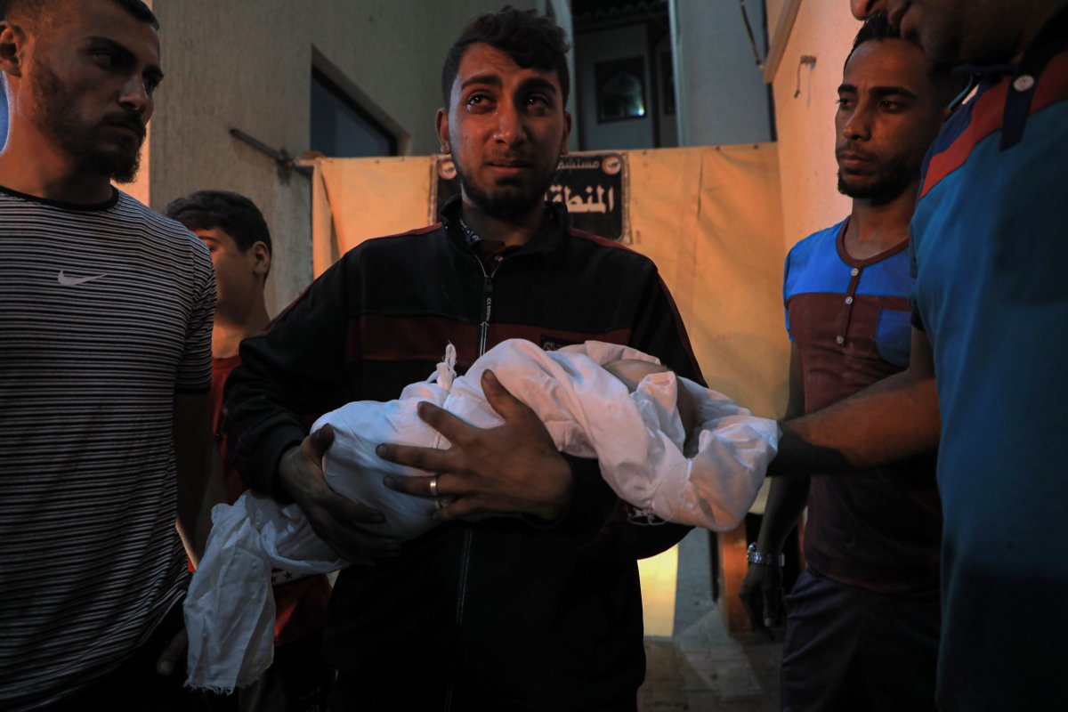 7일 팔레스타인 가자지구 남부 지역에서 이스라엘 공습을 받아 숨진 아기의 시신을 안고선 눈물을 흘리는 남성. 가자지구 보건부는 전쟁 기간 동안 수천 명의 어린 아이가 숨졌다고 밝혔다. 라파=신화뉴시스