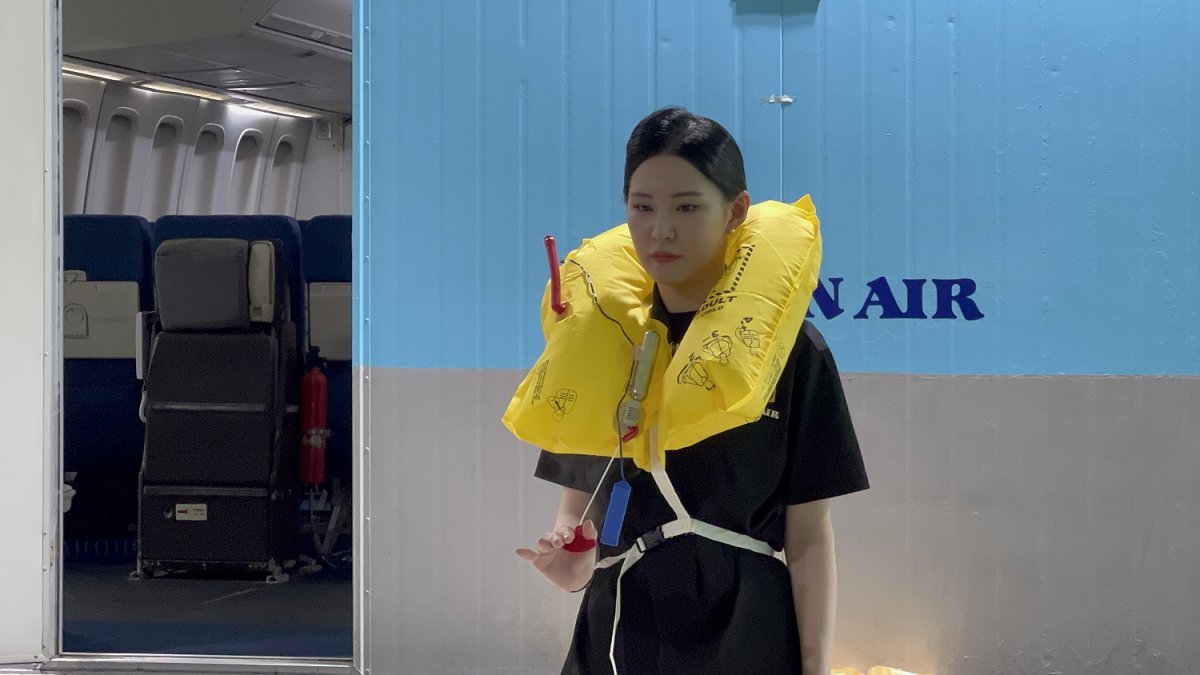 An employee shows how to wear a life jacket at the Korean Air cabin training center.