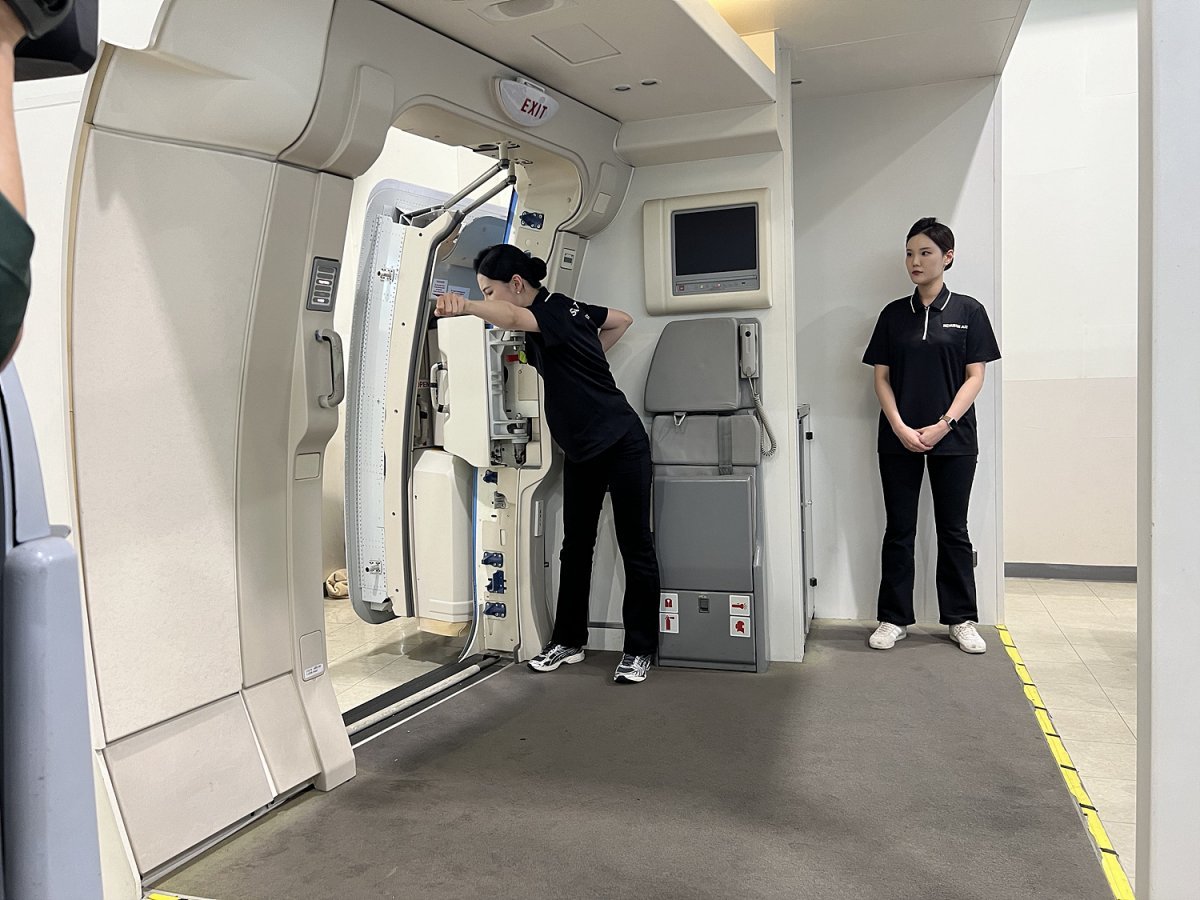 Demonstration of how to operate an aircraft door at the Korean Air Cabin Training Center.