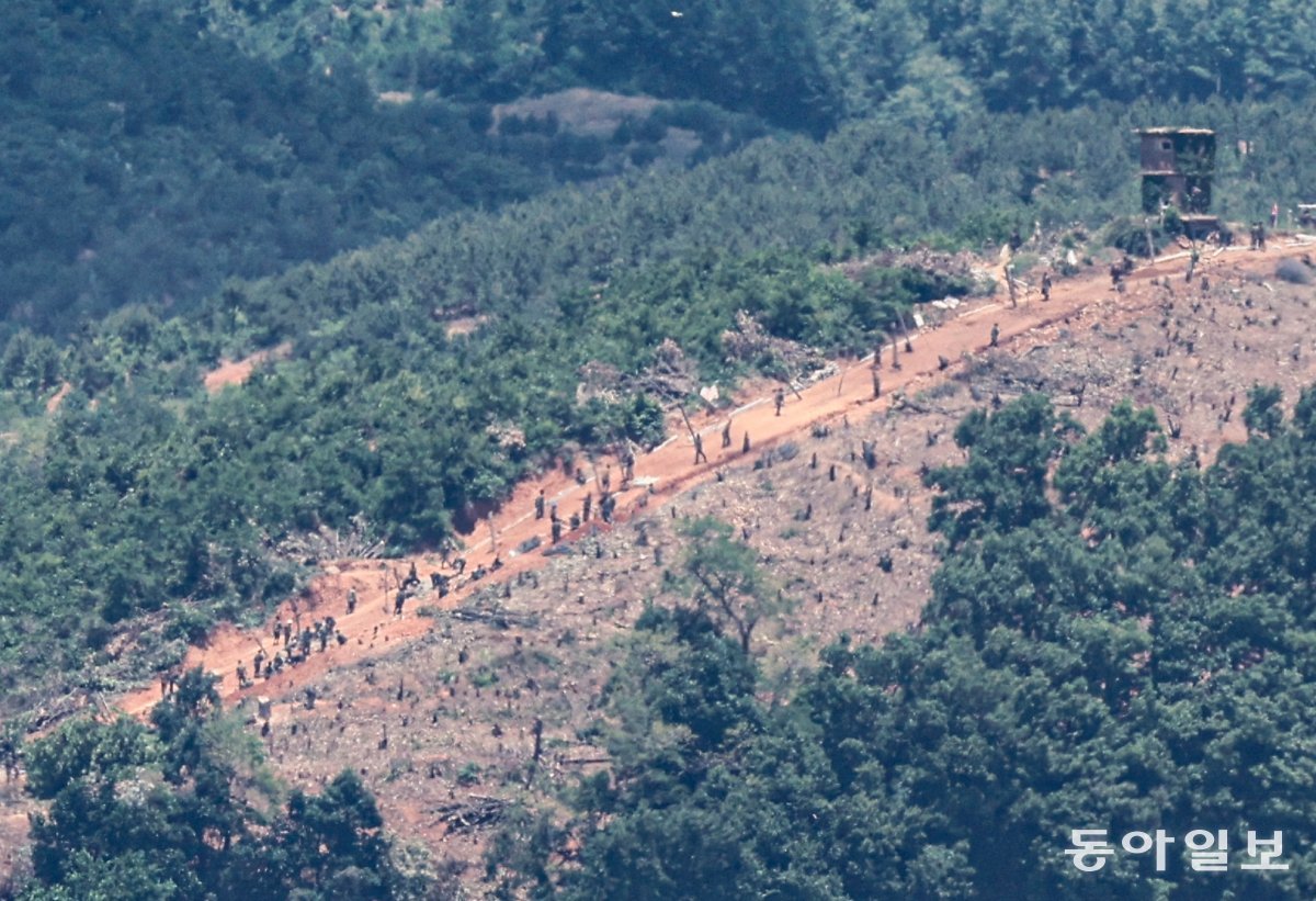 2일 오후 경기도 파주시 오두산통일전망대에서 바라본 임진강 변 북측의 한 초소 일대에서 북한군 수십 명이 철책을 설치하는 ‘대규모 진지 공사’ 장면이 포착됐다. 수백 그루의 나무가 잘린 능선을 따라 철책 설치에 필요한 장비들과 함께 북한군이 보인다. 파주=이한결 기자 always@donga.com