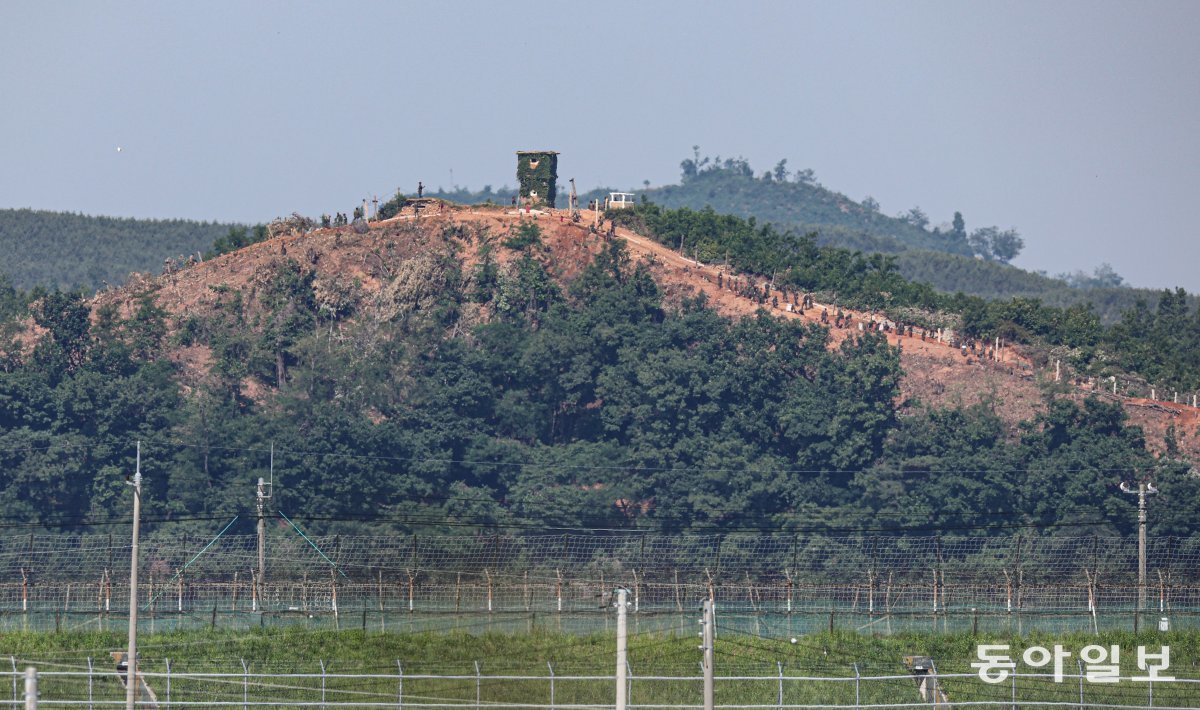 2일 오전 경기도 파주시 탄현면에서 바라본 임진강 변 북측의 한 초소 일대에서 북한군 수십 명이 철책을 설치하는 ‘대규모 진지 공사’ 장면이 포착됐다. 수백 그루의 나무가 잘린 능선을 따라 철책 설치에 필요한 장비들과 함께 북한군이 보인다. 파주=이한결 기자 always@donga.com