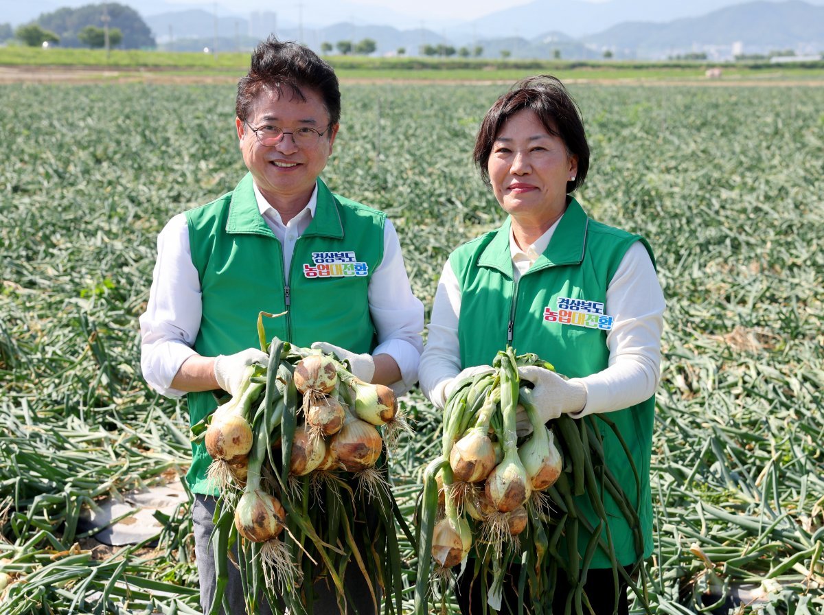 지난달 23일 경북 문경시 영순면 공동영농단지에서 이철우 경북도지사(왼쪽)와 송미령 농림축산식품부 장관이 농장에서 수확한 양파를 들어 보이며 미소 짓고 있다. 경북도 제공