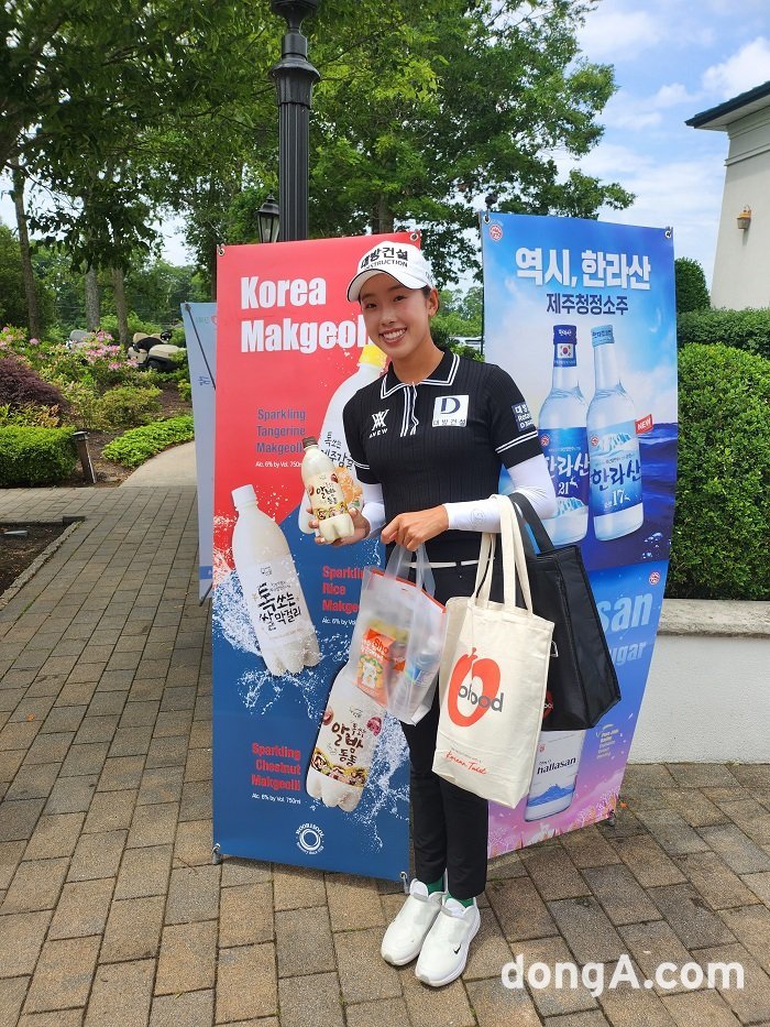 이번 LPGA 대회에 참가하는 노예림 프로가 ㈜우리술 세로 광고판 앞에서 기념사진을 촬영하고 있다.