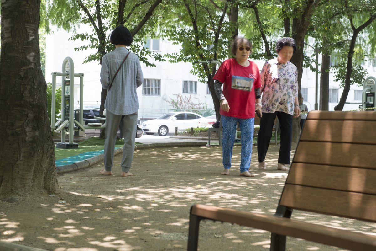 폭염주의보가 내려진 10일 낮 대구의 도심공원에서 시민들이 선글라스와 쿨토시를 착용한 채 맨발로 걷고 있다.2024.6.10/뉴스1