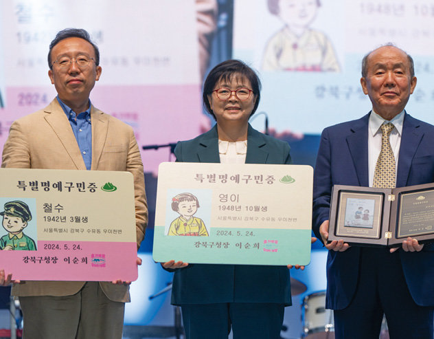 이순희 강북구청장(가운데)이 김주영 씨(오른쪽)와 그 아들에게 ‘철수와 영이’ 특별 명예구민증을 수여했다. 강북구 제공