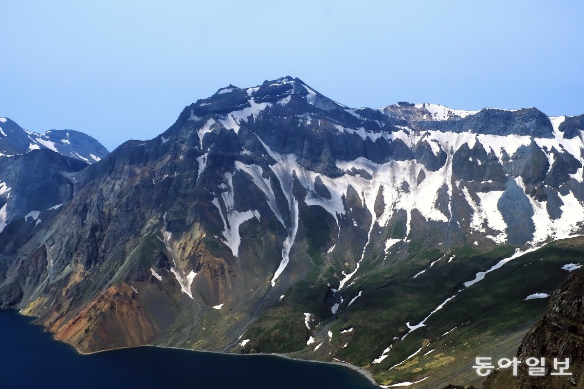 지난 11일 백두산(2,744m) 천지 북파 지역 천문봉에서 바라본 관일봉에 녹지 않은 눈과 얼음이 남아있다.  백두산=이한결 기자 always@donga.com