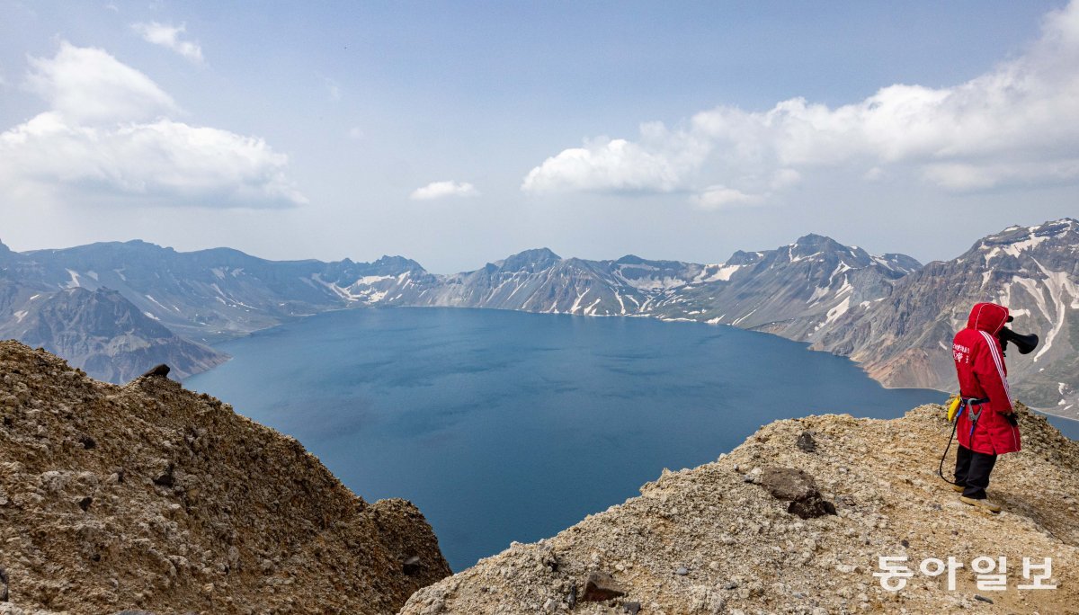 지난 11일 백두산(2,744m) 북파 지역 천문봉에서 보이는 천지 앞에 중국인 관계자가 확성기로 관광객들을 통제하고 있다. 백두산=이한결 기자 always@donga.com