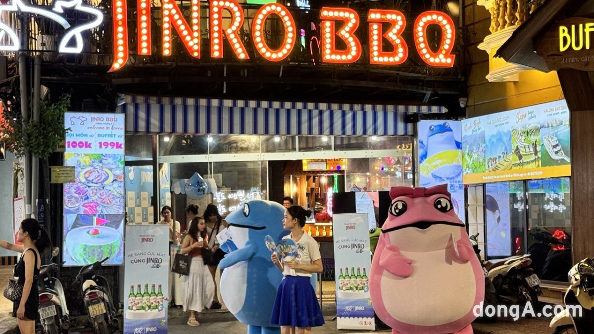 베트남 하노이의 ‘진로비비큐(JINRO BBQ)’ 매장 앞에서 판촉사원과 두꺼비 캐릭터가 소주 홍보를 펼치고 있다. 윤우열 동아닷컴 기자 cloudancer@donga.com