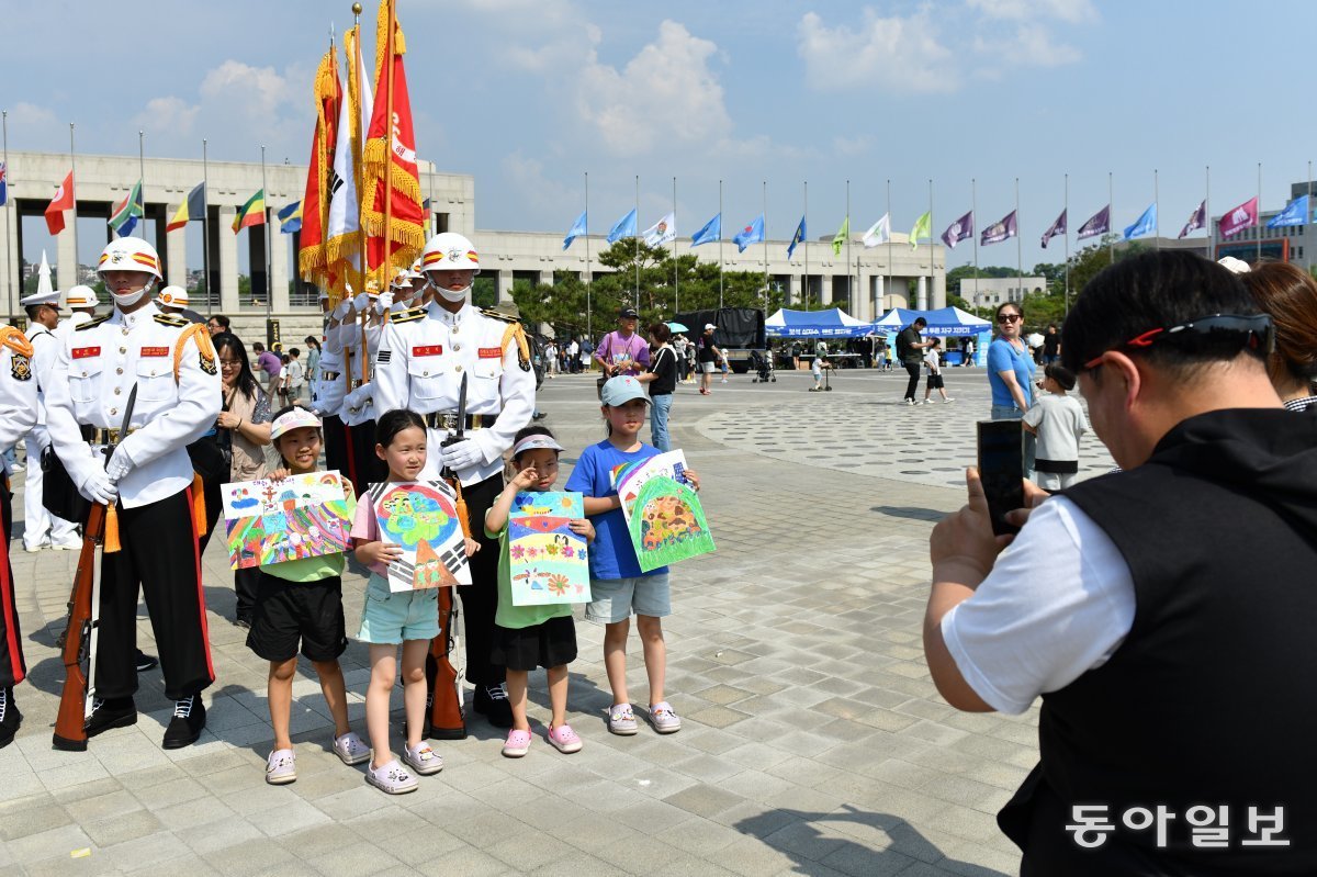 6일 서울 용산 전쟁기념관에서 열린 현충일 그림대회에 참석한 어린이들이 그림을 들고 장병들 앞에서 사진을 찍고 있다.