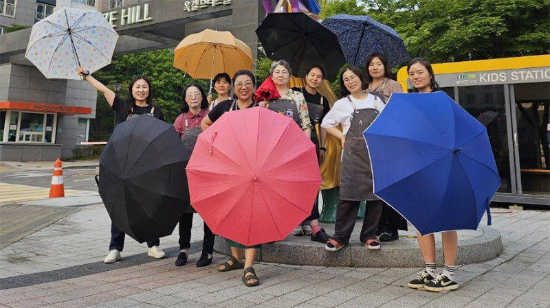 경기 부천시 소사구 옥길동 브리즈힐아파트 주민들이 부천시에 기부한 헌 우산을 들고 환하게 웃고 있다. 부천시 제공