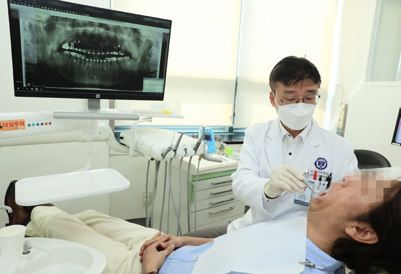 이기준 연세대 치과대학장이 교정을 위해 찾아온 중년 남성 환자의 치아 상태를 확인하고 있다. 연세대 치과병원 제공