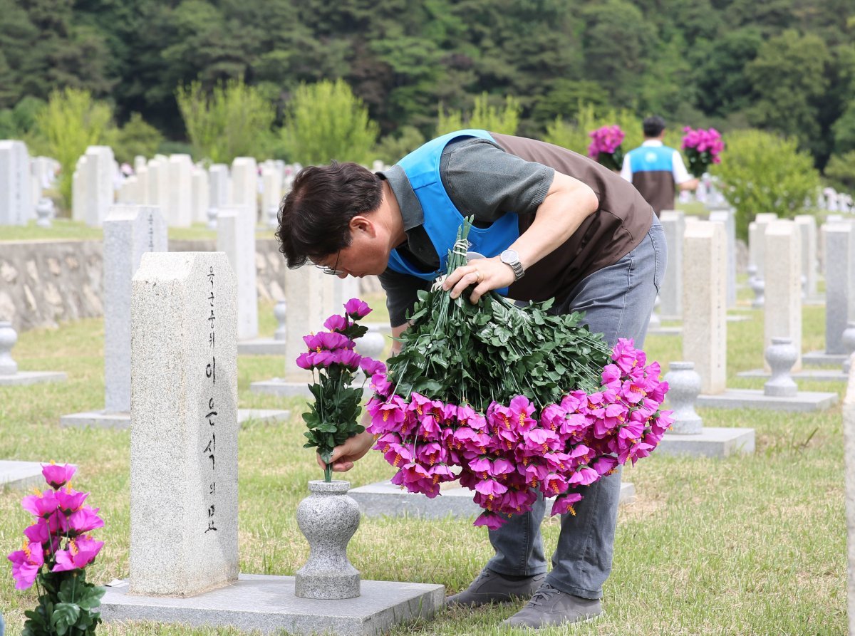 지난달 24일 국립서울현충원에서 GS리테일 임직원이 묘역 정화 및 주변 환경 정비 봉사활동을 진행했다. 사진은 묘비에 헌화하는 모습.