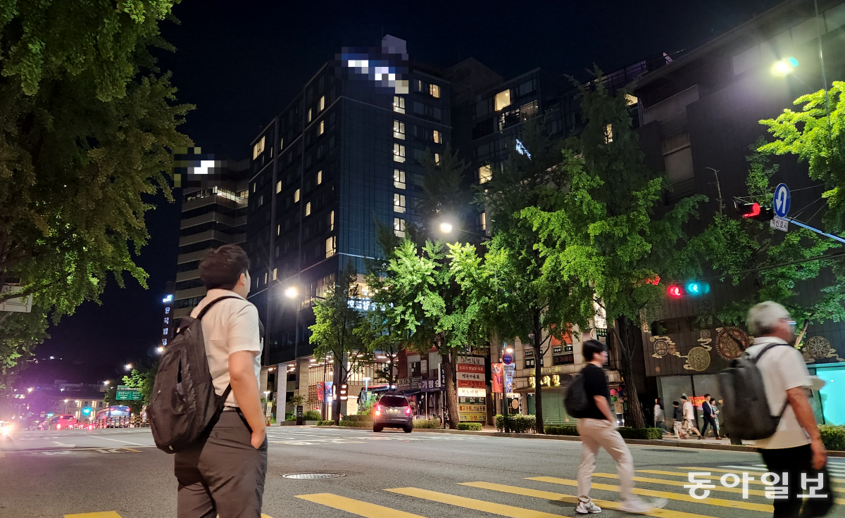 김민우(왼쪽)가 이달 3일 서울 종로구의 한 호텔 앞에 서 있다. 그는 이곳에서 한 달간 불법사채 조직의 ‘이 대리’가 되기 위한 교육을 받았다.
