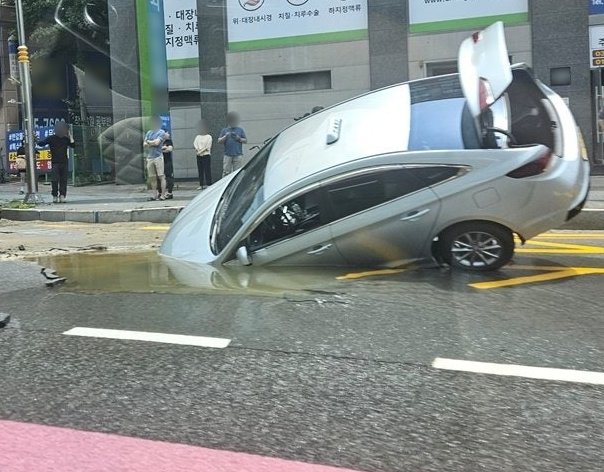 24일 경기 평택시 이충동 한 도로에서 발생한 싱크홀에 택시가 빠진 모습. 온라인 커뮤니티 캡처
