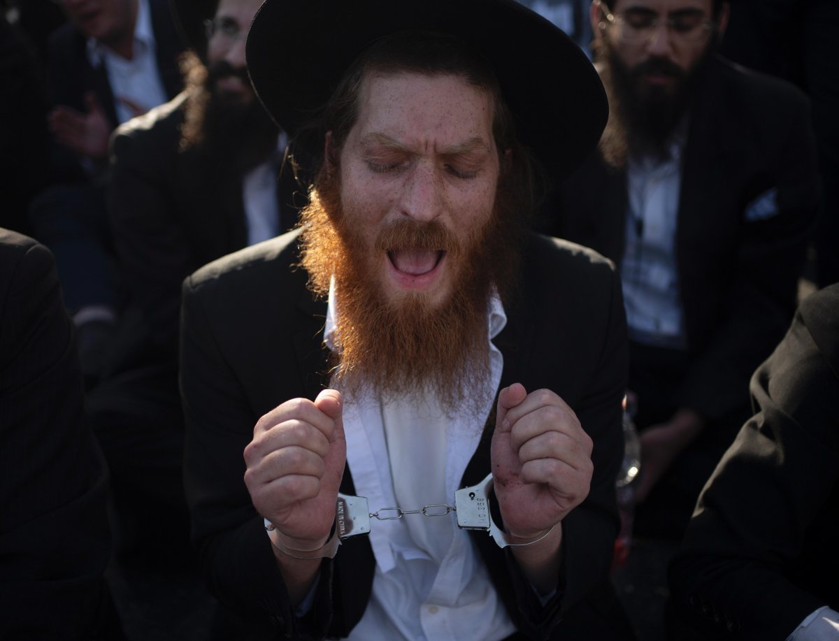 이달 2일 이스라엘 예루살렘에서 한 하레디 남성이 손목에 수갑을 채운 채 징집 반대 시위를 하고 있다. 
예수살렘=AP 뉴시스