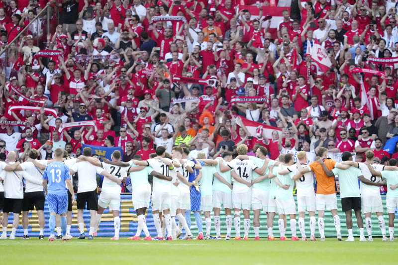 오스트리아 축구 대표팀 선수들이 26일 유럽축구선수권대회(유로) 조별리그 D조 최종 3차전에서 네덜란드를 3-2로 꺾고 조 1위로
 16강에 진출한 뒤 어깨동무를 한 채 경기장을 찾은 자국 팬들을 향해 함께 기뻐하고 있다. 베를린=AP 뉴시스