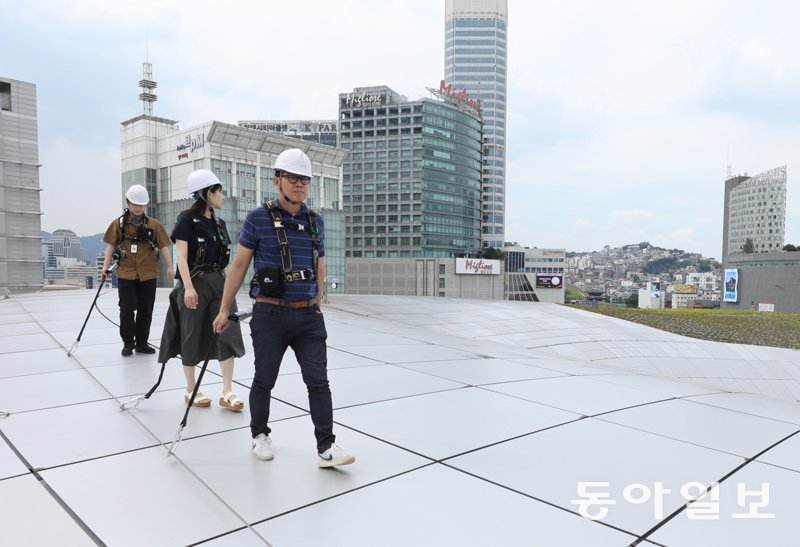 안전벨트에 와이어를 연결해 알루미늄 패널로 이뤄진 곡선형 지붕을 안전하게 걸을 수
 있다. 서울시는 DDP 개관 10주년을 맞아 10월부터 DDP 지붕을 시민들에게 개방한다. 신원건 기자 
laputa@donga.com