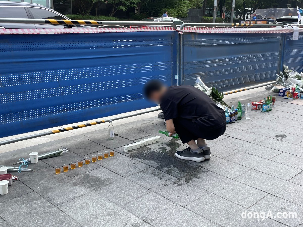 한 시민이 희생자들을 추모하기 위해 술을 따르고 있다. 이혜원 동아닷컴 기자 hyewon@donga.com