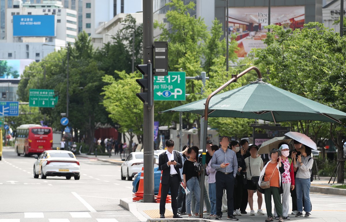 서울 낮 최고기온이 30도를 기록한 지난달 17일 서울 종로구 광화문 횡단보도에서 시민들이 그늘막 아래에 모여 햇빛을 피하고 있습니다. 그늘막과 녹지, 냉방 효율적인 건물설계 등 다양한 대응방안을 적극적으로 고민하는 것이 기후변화 시대의 건강하고 평화로운 생존법 아닐까요? 뉴스1