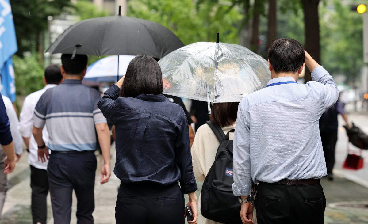 가을을 재촉하는 소나기가 내린 30일 서울 영등포구 여의도 일대에서 우산을 미처 챙기지 못한 시민들이 손으로 머리를 가린 채 발걸음을 재촉하고 있다. 2023.8.30 뉴스1