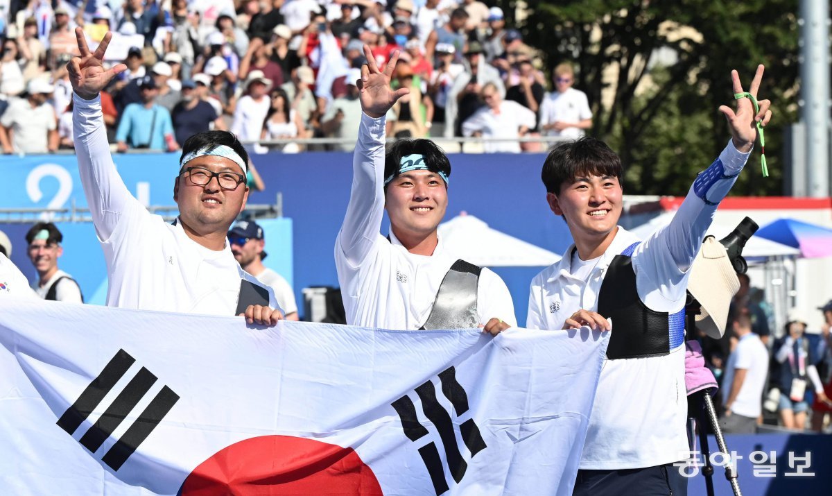 한국 남자 양궁 대표팀이 30일 파리 올림픽 단체전에서 대회 3연패를 달성한 뒤 관중석을 향해 손가락 3개를 펴 보이며 챔피언 세리머니를 하고 있다. 왼쪽부터 김우진, 이우석, 김제덕. 파리=양회성 기자 yohan@donga.com