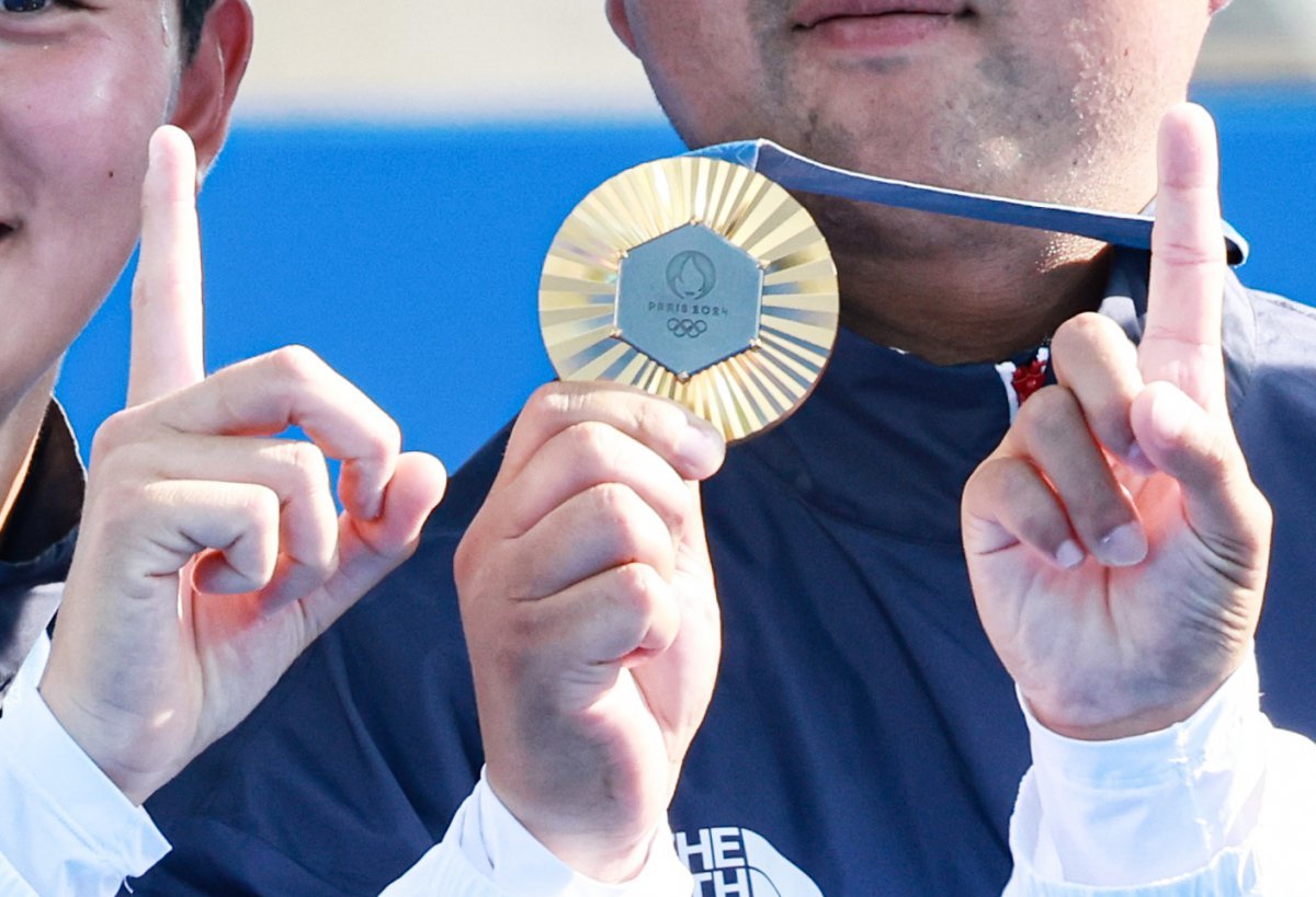 대한민국 양궁대표팀 김우진, 김제덕, 이우석이 30일(한국시간) 프랑스 파리 앵발리드에서 열린 2024 파리올림픽 양궁 남자 단체전 결승 시상식에서 메달과 손가락을 이용해 대한민국의 101번째 금메달을 표현하고 있다. 2024.7.30/뉴스1