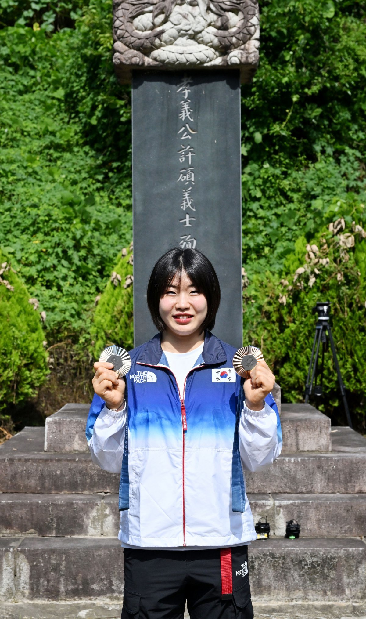 6일 대구 군위군 삼국유사면 화수리의 독립운동가이자 현조 할아버지인 허석 지사 순국기적비를 찾은 한국 여자 유도 국가대표 허미미(22)가 2024 파리 올림픽에서 따온 메달을 들어보이며 미소짓고 있다. 경북도 제공