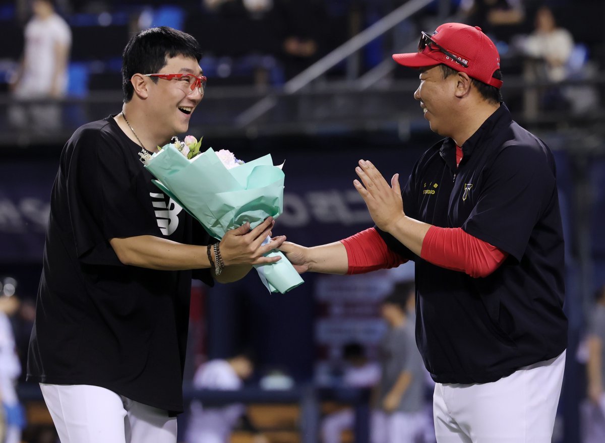 10일 오후 서울 송파구 잠실야구장에서 열린 프로야구 ‘2024 신한 SOL 뱅크 KBO리그’ KIA 타이거즈와 LG 트윈스의 경기, 이날 선발 등판으로 KBO리그 최초로 400경기 등판 신기록과 함께 4회말 선두 타자 오스틴 딘을 투수 직선타로 잡아내 올 시즌 100이닝을 채우면서 역대 3번째로 11시즌 연속 100이닝 기록을 세운 양현종이 경기 후 이범호 감독에게 꽃다발을 받고 있다. (기아 타이거즈 제공) 2024.7.10 뉴스1